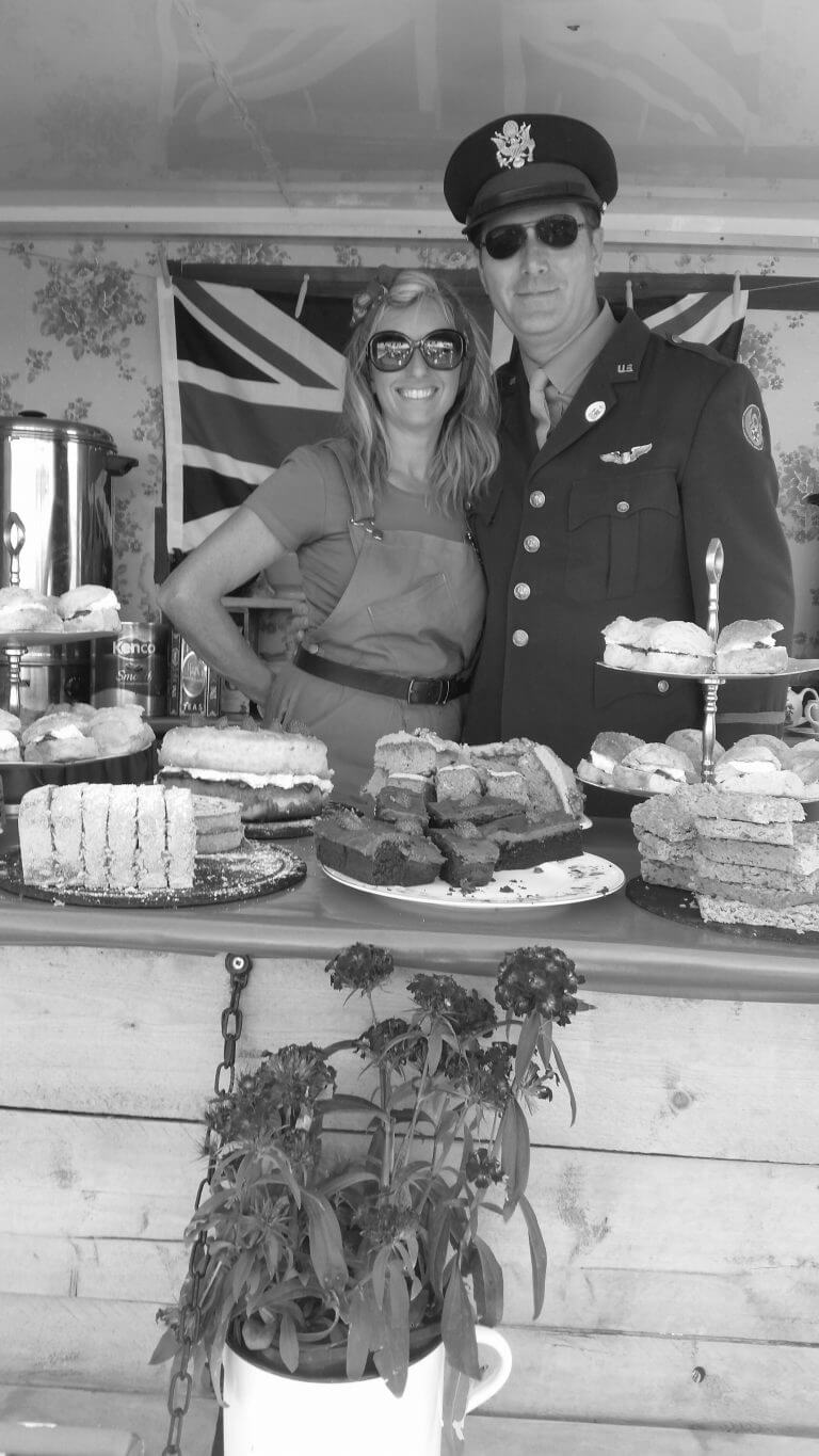 Landgirl with pilot serving cakes and tea at Outside Catering Event